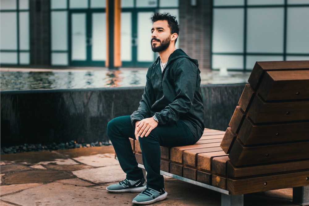 man sitting on wooden lounge