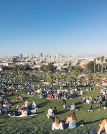 A vibrant community gathering in a green park filled with people participating in activities.