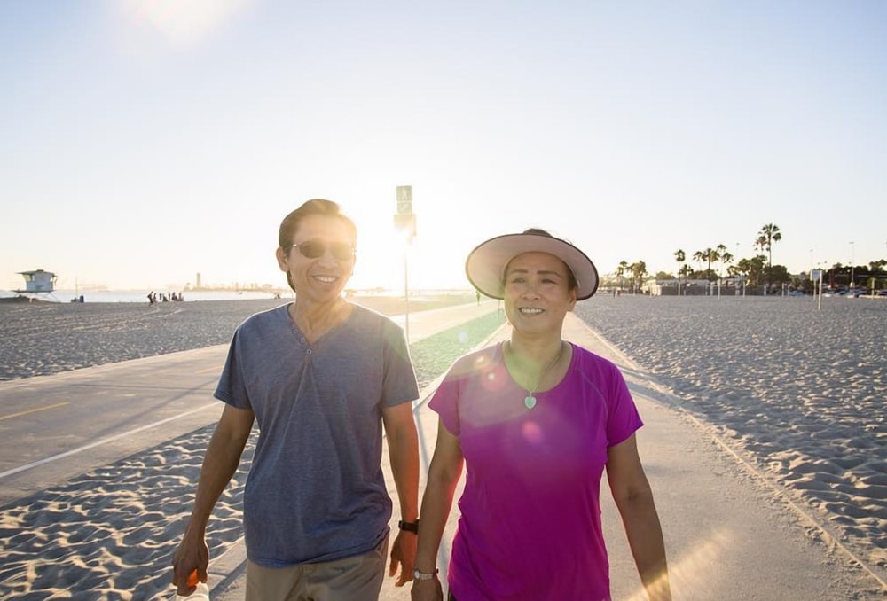 man and woman walking on gray asphalt