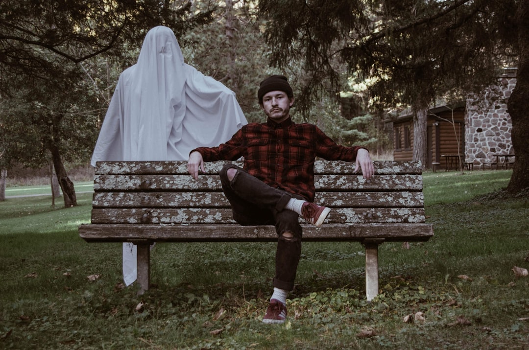 man sitting on brown bench