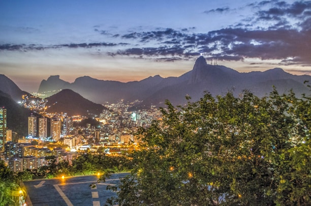 A vibrant view of Rio de Janeiro's Christ the Redeemer statue overlooking the city at sunset.