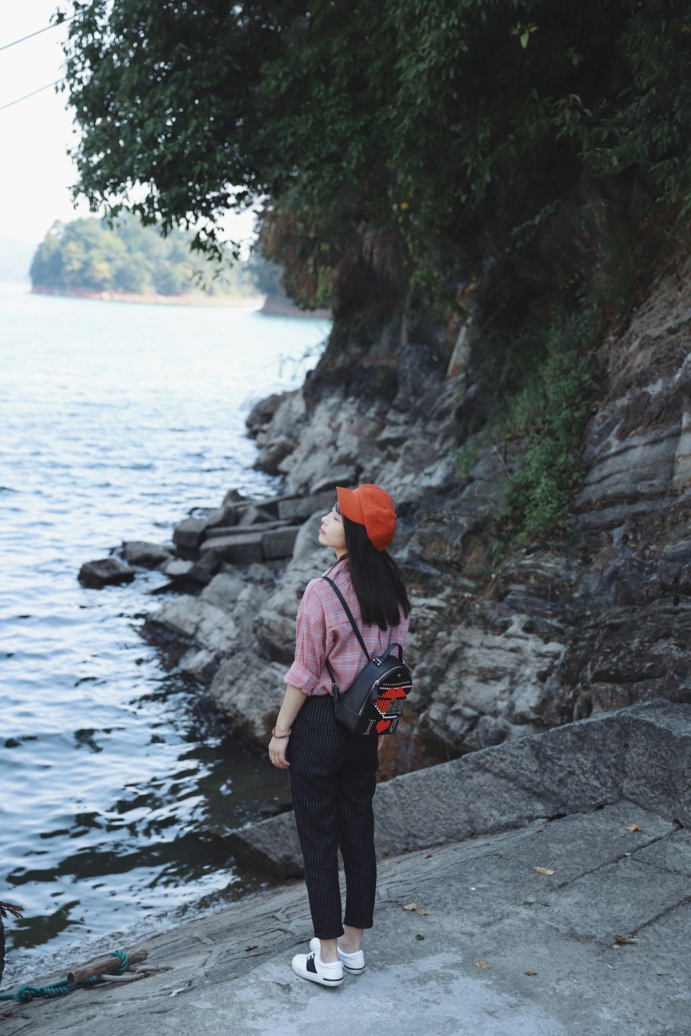 woman standing in front of body of water during daytime