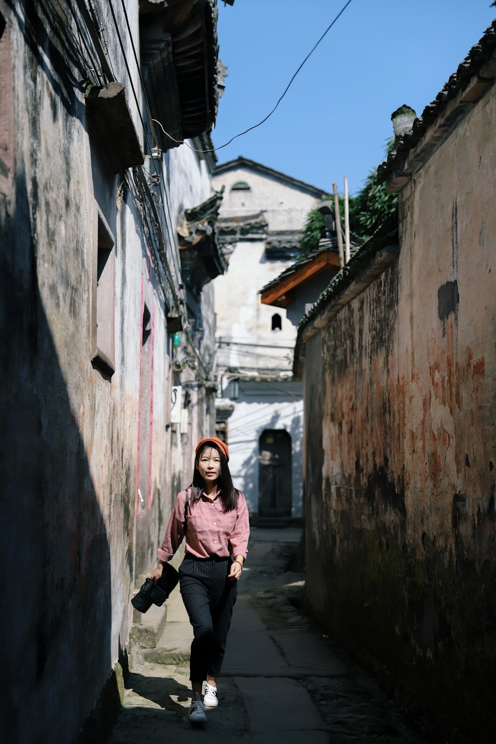 woman wearing pink dress shirt walking on hallway