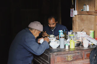 An elderly couple enjoying a warm meal together at a rustic wooden table.
