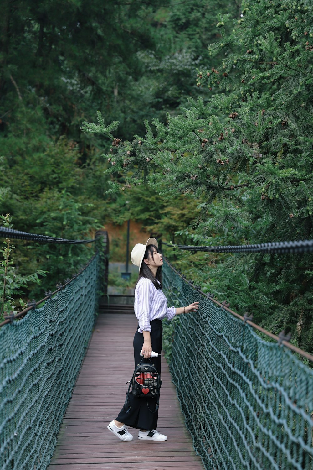 woman standing on brown hanging bridge