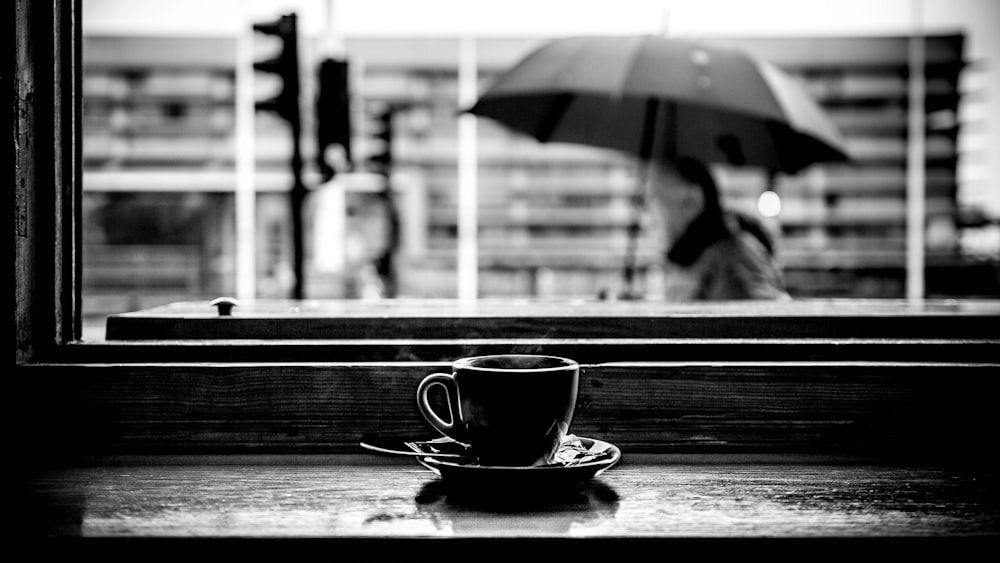 Graustufenfoto der Teetasse auf der Tischplatte