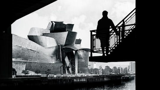 grayscale photography of person standing on staircase in Bilbao Spain