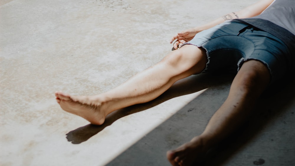 man lying on gray floor