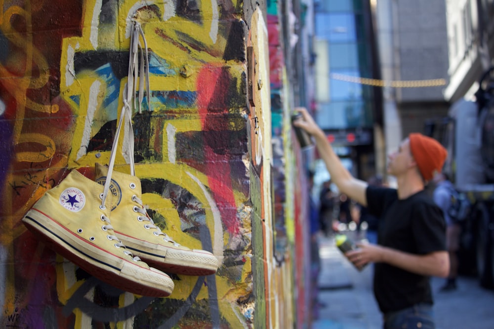 selective focus photography of yellow Converse All-Star sneakers on yellow wall