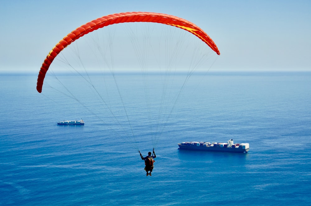Mann am Fallschirm über dem Meer