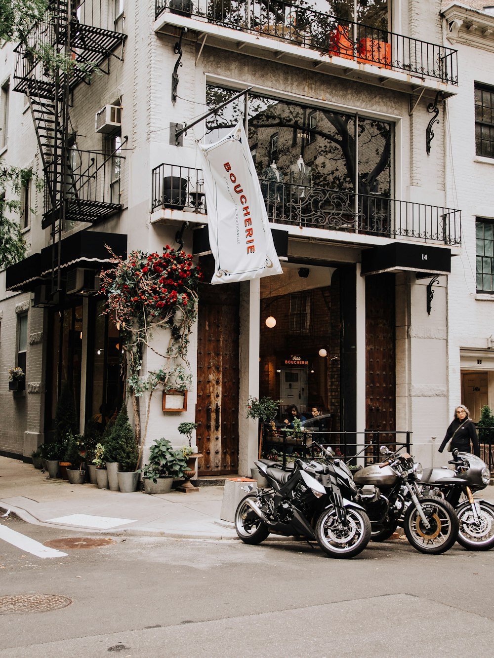 three motorcycles parked near white building