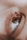 A close-up shot of a human eye with detailed focus on the eyelashes and the smooth surrounding skin texture. The eye reflects some light, adding to the depth and detail of the image.