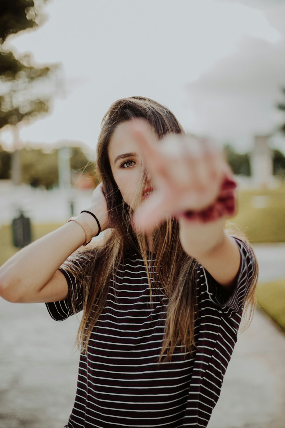 woman wearing black-and-white striped t-shirt pointing finger