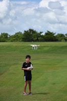A young mentee smiling broadly while learning to pilot a drone under a veteran mentor’s guidance.