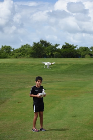 A young mentee smiling broadly while learning to pilot a drone under a veteran mentor’s guidance.