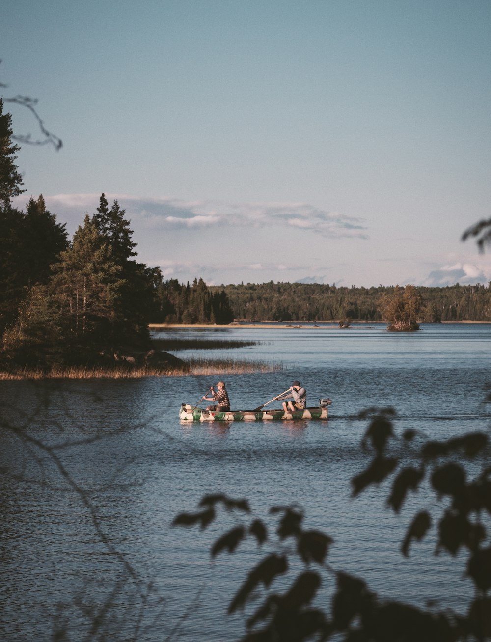 two men rowing boats in lake