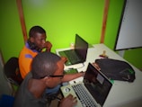 two men using laptop computes