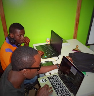 two men using laptop computes