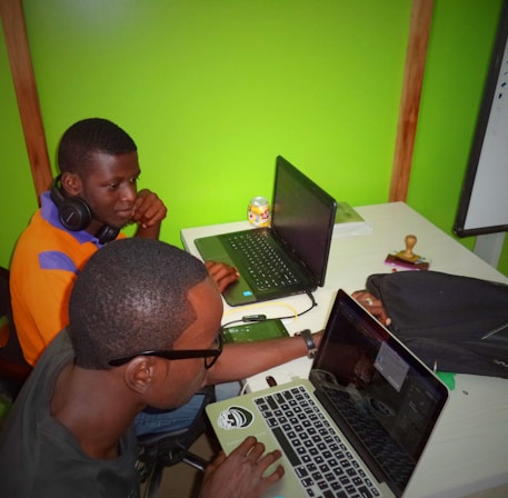 two men using laptop computes