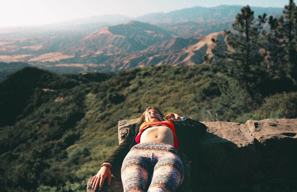 woman lying on ledge during daytime