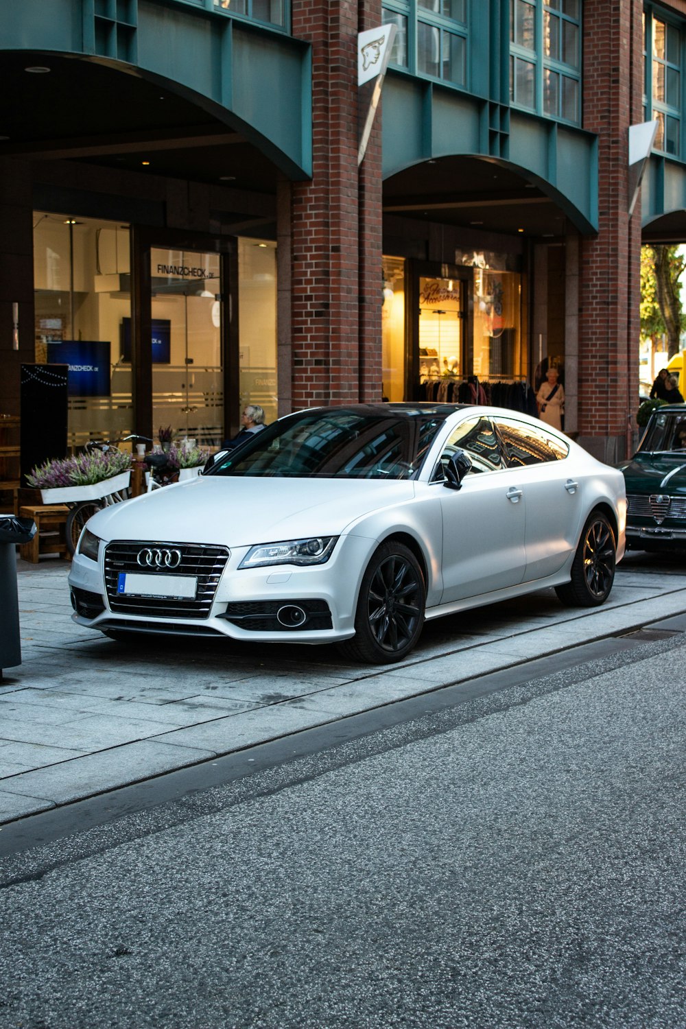 berline Audi argentée garée dans la rue à côté de la restauration