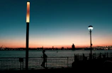 Lifestyle athlete stretching before a sunrise run along an urban waterfront.