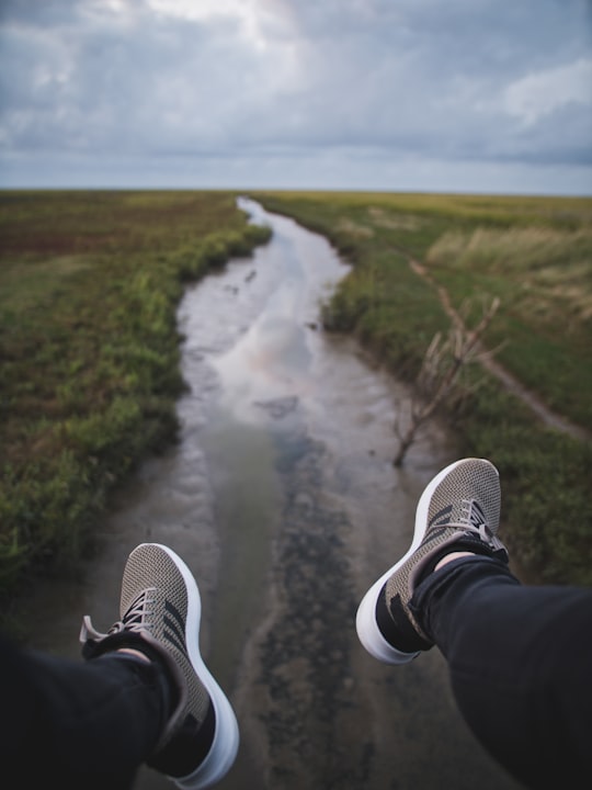 person wearing white-and-black Adidas sneakers in Noordpolderzijl Netherlands