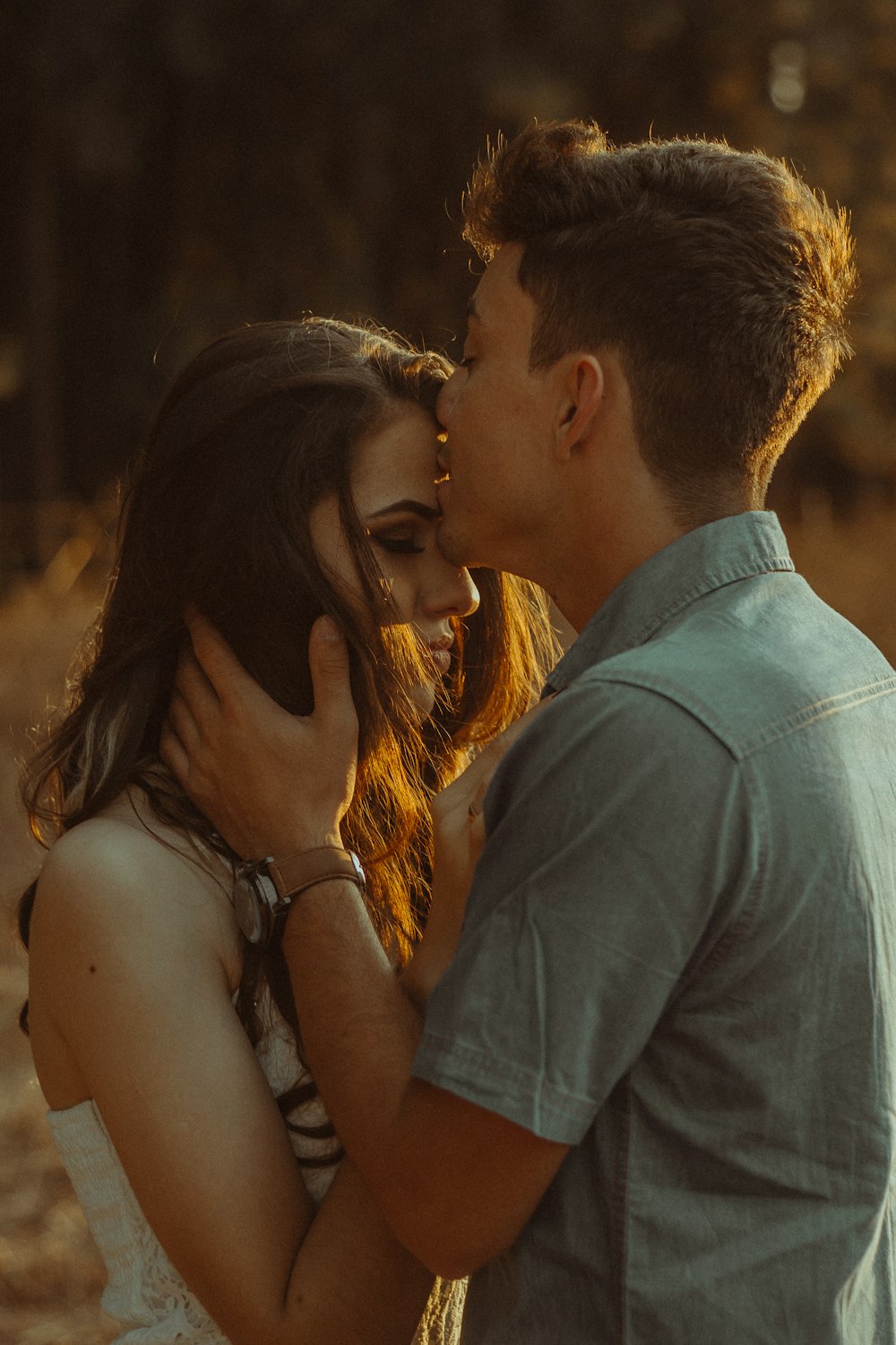 man kissing woman forehead