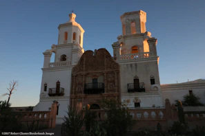 Sunset casting warm light on the historic adobe walls of a Spanish mission in Baja