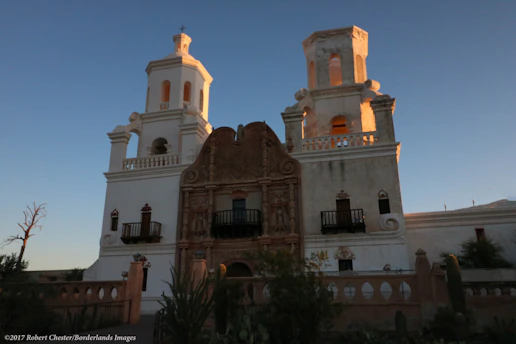 Sunset view of San Miguel de Allende's iconic Parroquia de San Miguel Arcángel with warm colonial architecture in the foreground.