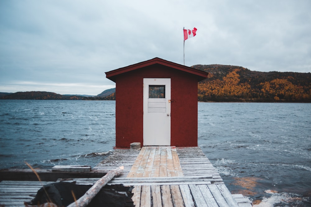 red and white wooden shed at the end of the pier