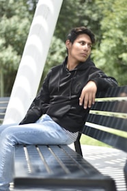 Close-up of a soft, textured hoodie draped over a concrete bench in a sunlit park.
