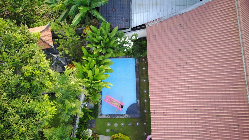 top view of woman lying on pink swimming bed at at swimming pool