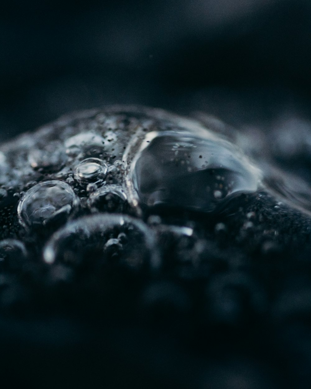 um close up de gotículas de água em uma superfície preta