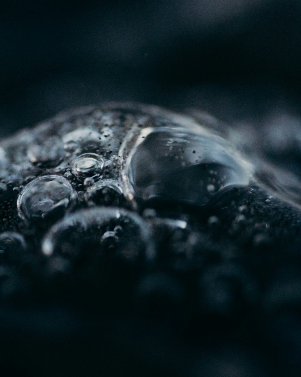 a close up of water droplets on a black surface