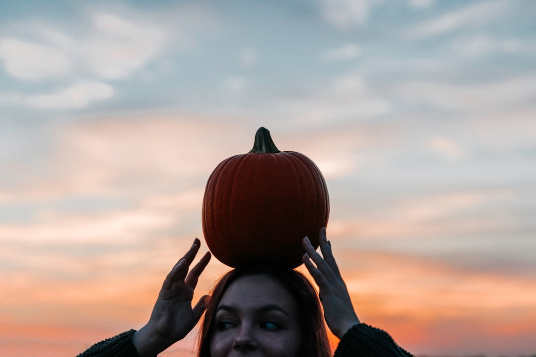 woman carrying pumpkin on head