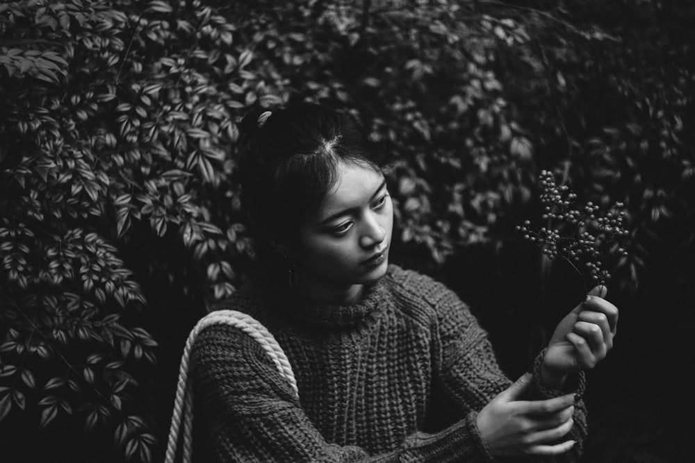 grayscale photography of woman holding leaf