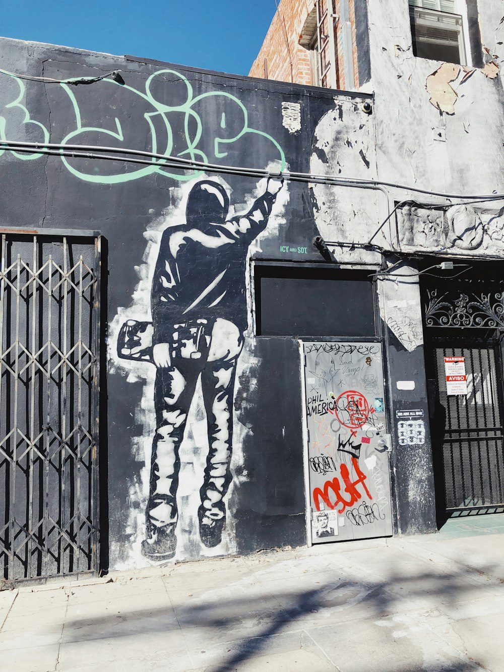 man holding skateboard graffiti during daytime