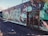 A wall featuring vibrant graffiti art in a variety of colors and abstract designs. The artwork includes intricate patterns and lettering, with a mix of teal, green, orange, and black hues. The area is outdoors and the scene includes a metal gate with engraved details.