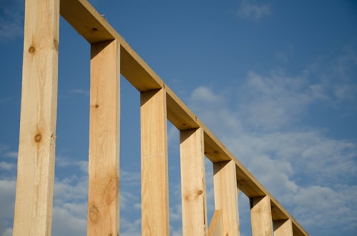 Craftsman installing wooden beams on a custom wooden structure.
