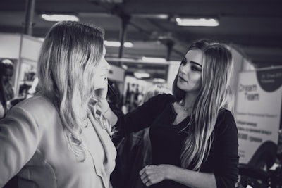 Makeup artist applying elegant eye makeup on a model in a soft-lit studio.