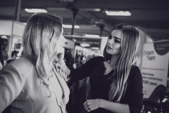 A makeup artist carefully applying bridal makeup in a softly lit studio.