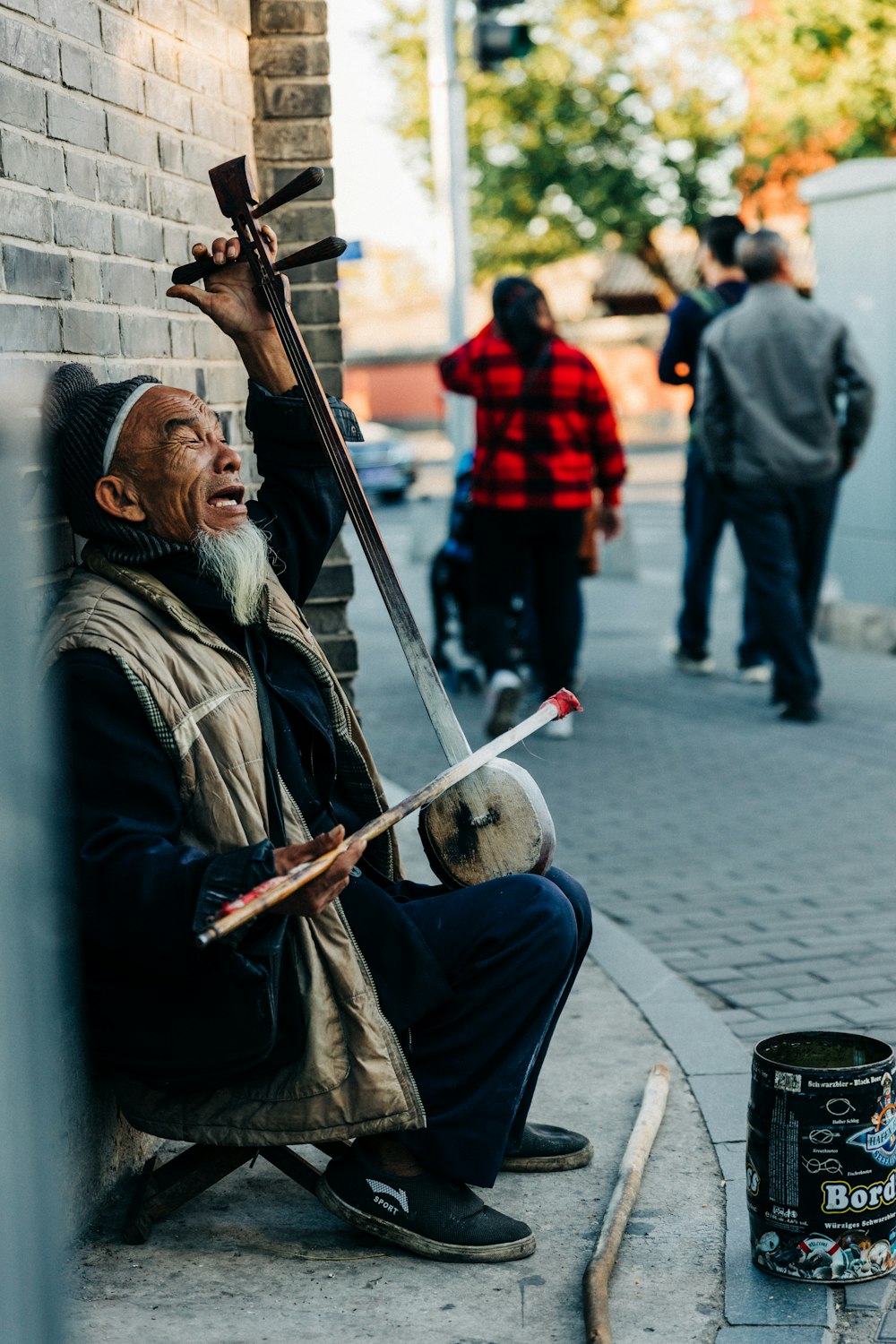 man playing musical instrument on sidewalk