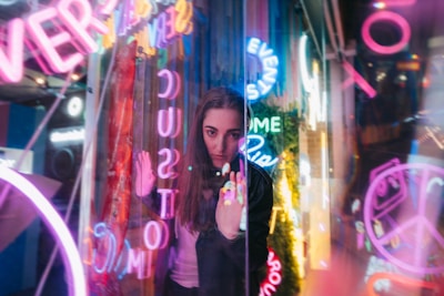 A vibrant scene of a woman engaging playfully on camera, with colorful background lights.