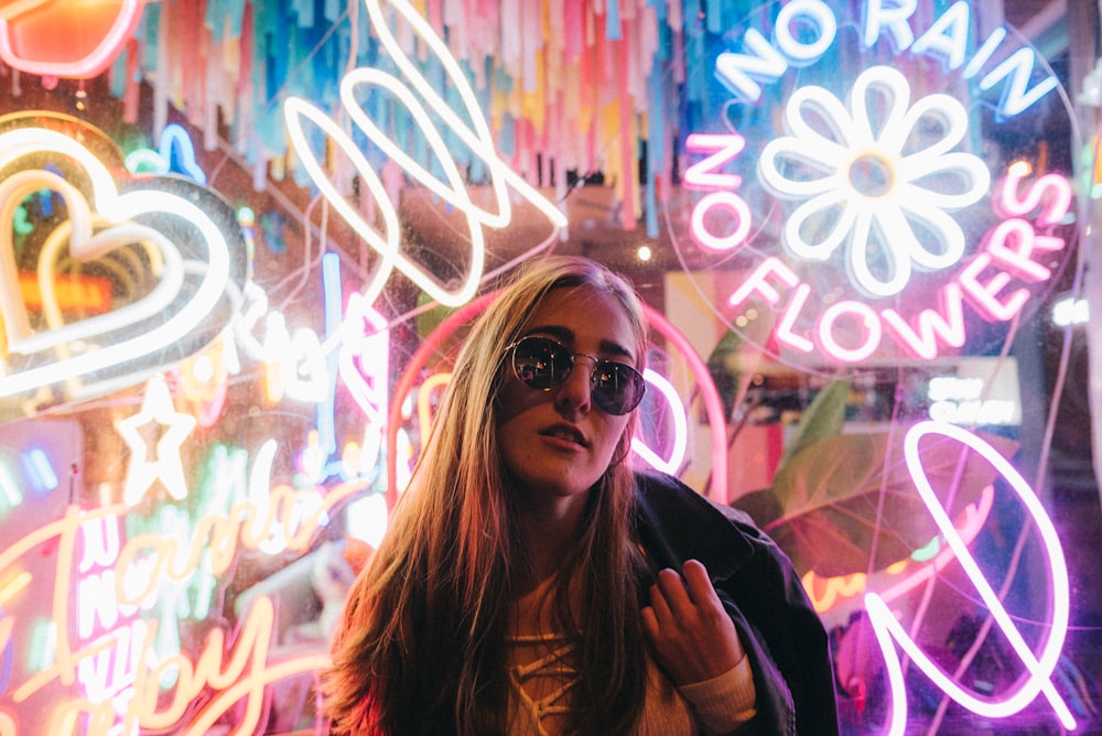 woman standing by neon signages