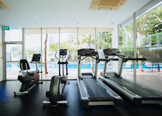 black and grey treadmill and stationary bikes