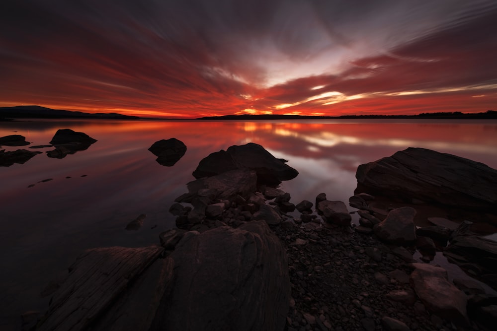 rocks in body of water during golden hour