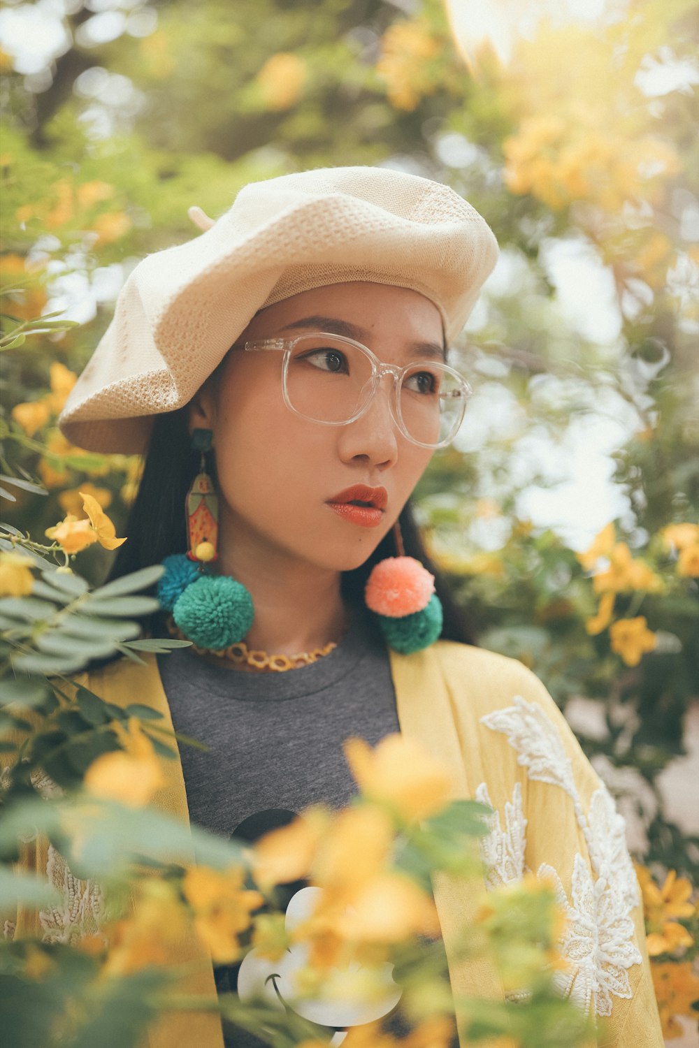 selective focus photography of woman looking left while surrounded by yellow petaled flowers