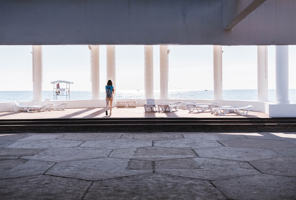 person standing outside of building overlooking sea
