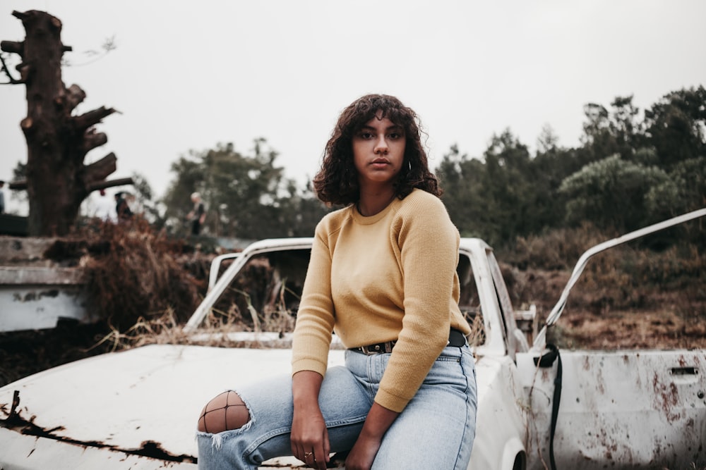 woman sitting on vehicle on focus photography